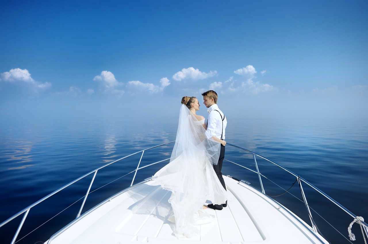 Happy bride and groom hugging on a yacht